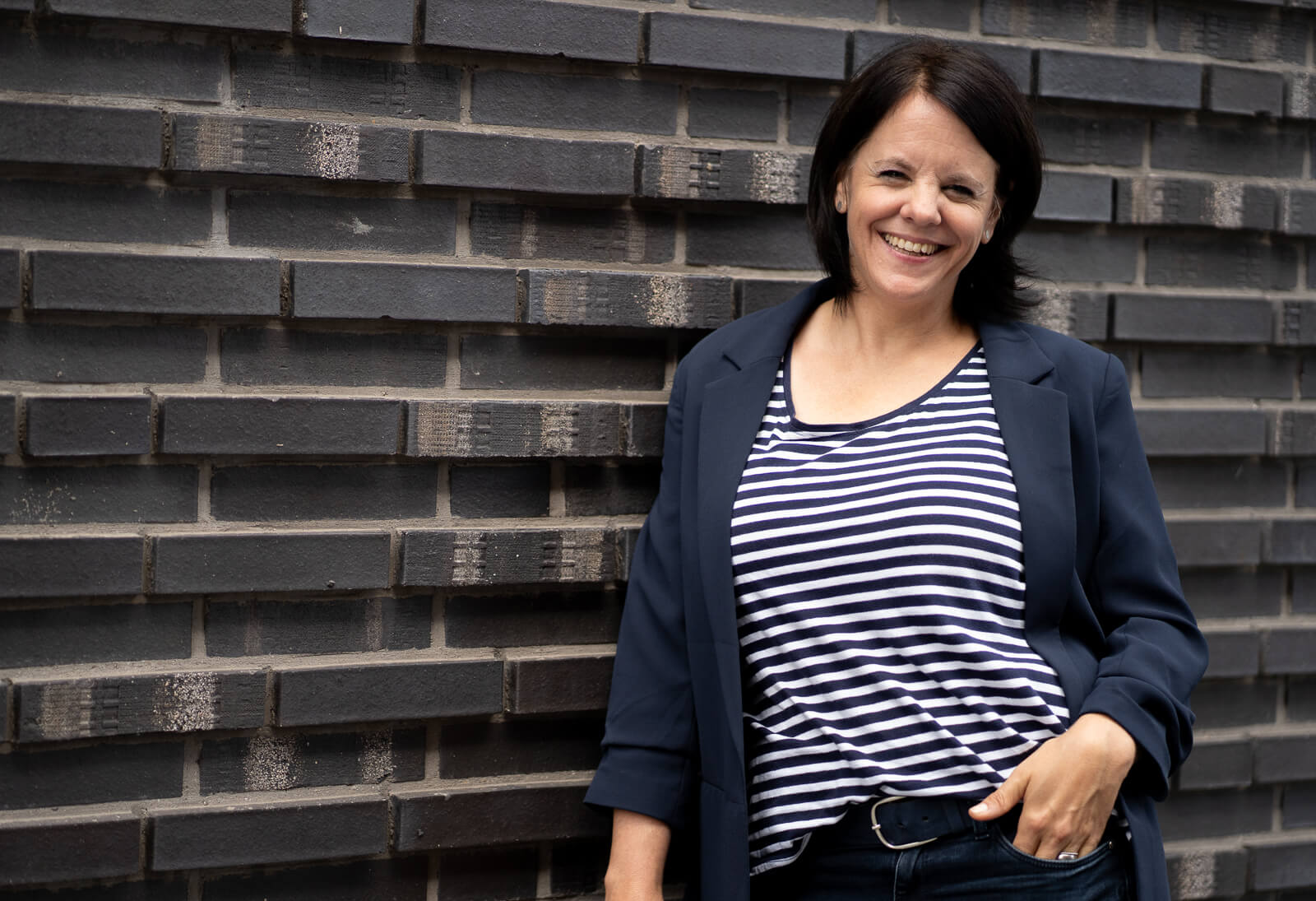 Kitafotos Herford Die Fotografin in Herford lehnt an einer Hauswand im Marthaviertel. Sie macht Kitafotos