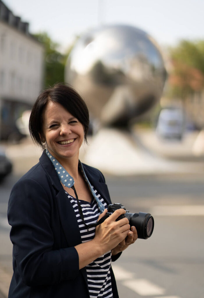 Die Fotografin aus Herford steht vor der Marthakugel und schaut in die Kamera