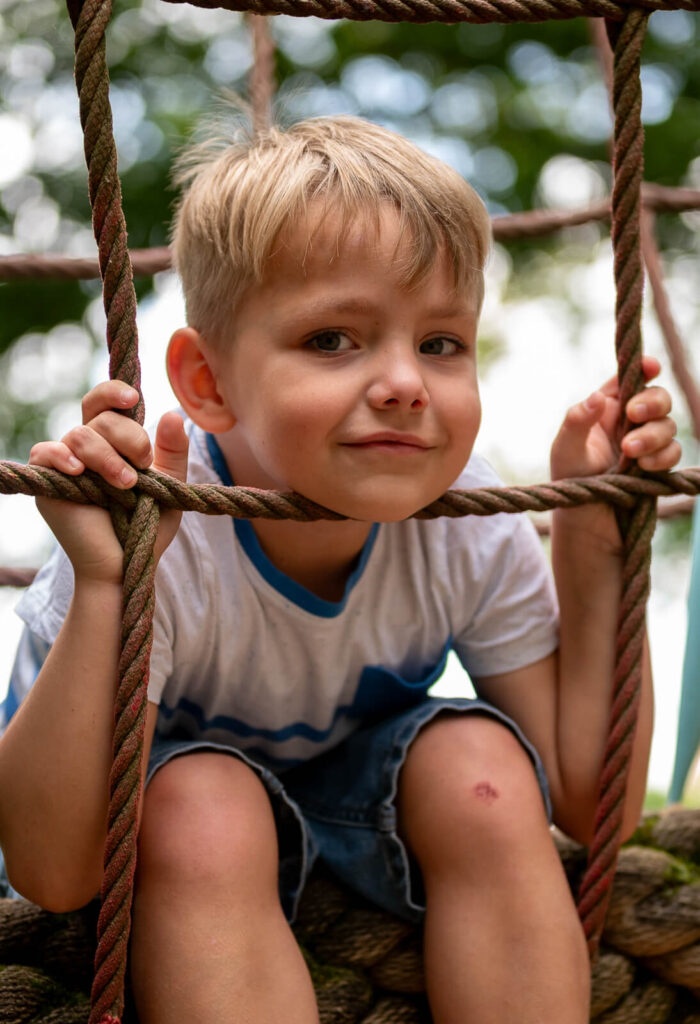 Kitafotos in Herford: Ein Junge sitzt auf einem Klettergerüst