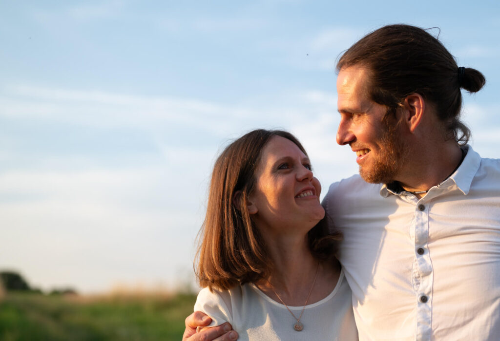 Ein Ehepaar steht auf einem Feld im Sonnenuntergang